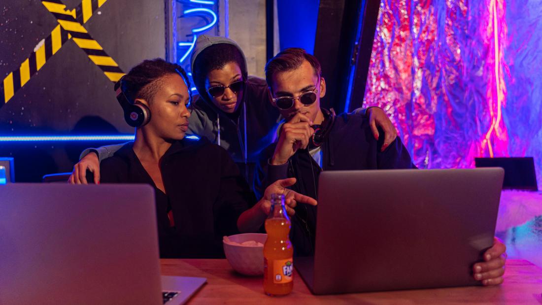 Three young individuals looking at a laptop attempting to resolve a crime