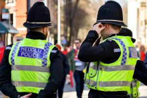 Image of two North Wales Police Officers on duty standing on a busy street