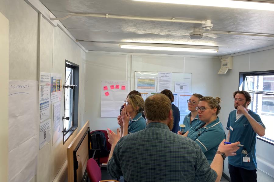 Member of staff speaking to a group of clinicians at the local Health Board during a stakeholder consultation session
